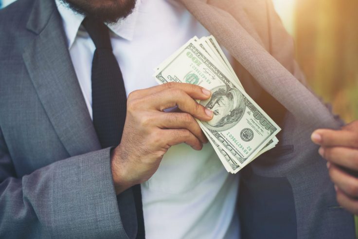 Businessman Placing Money Into His Pocket. generic image of man with money